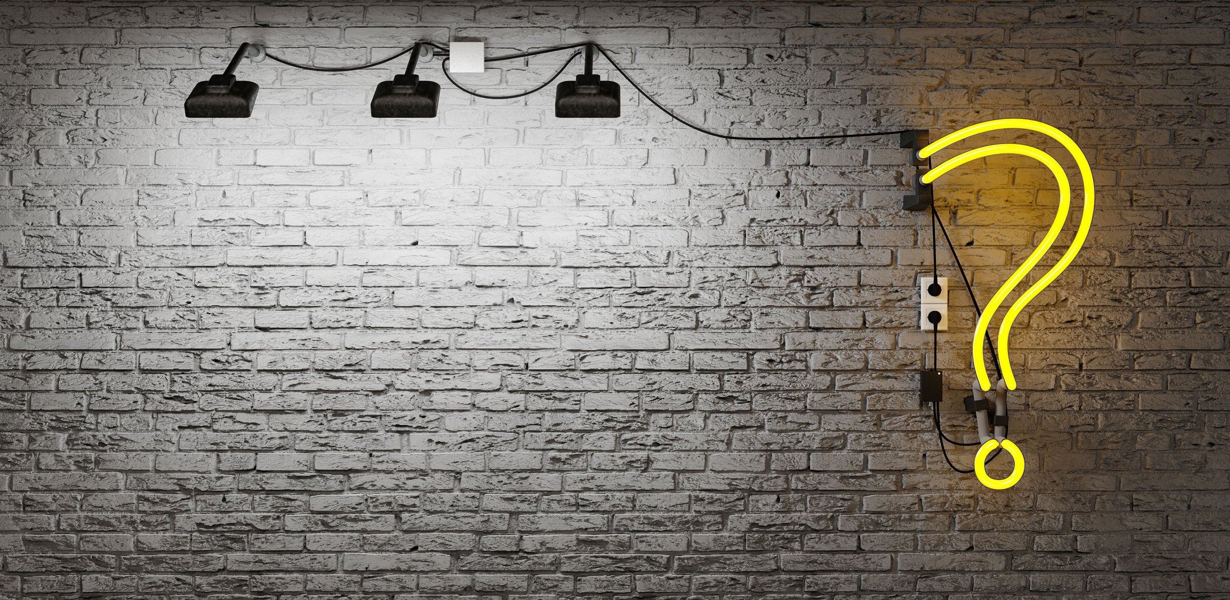 Spotlit grey brick wall with a neon question mark