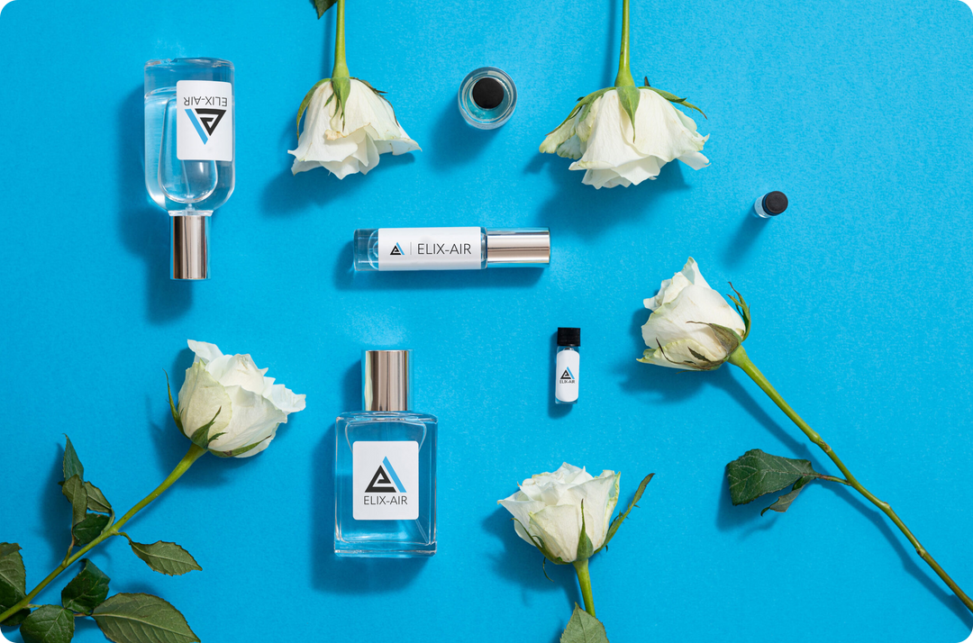 Collection of perfume bottles on a blue background surrounded by single rose flowers