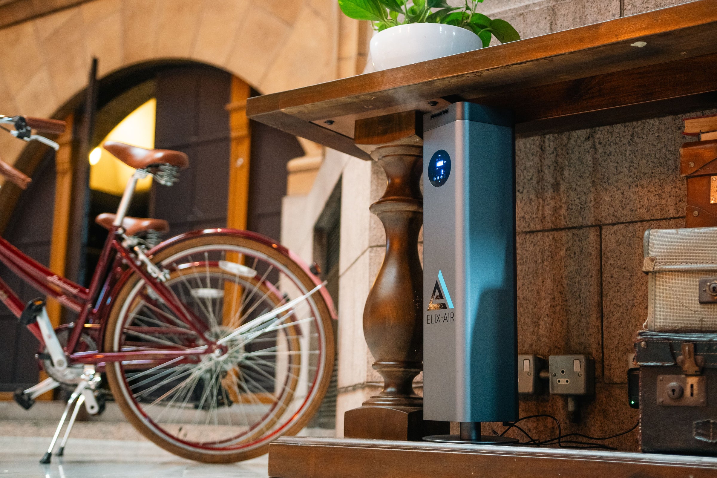 Scent Machine Scent Diffuser tower in a luxury hotel environment, positioned under a desk next to some decorative bicycles